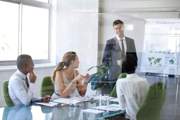 A man presents to an audience, engaging them with his speech and visual aids during a professional gathering.